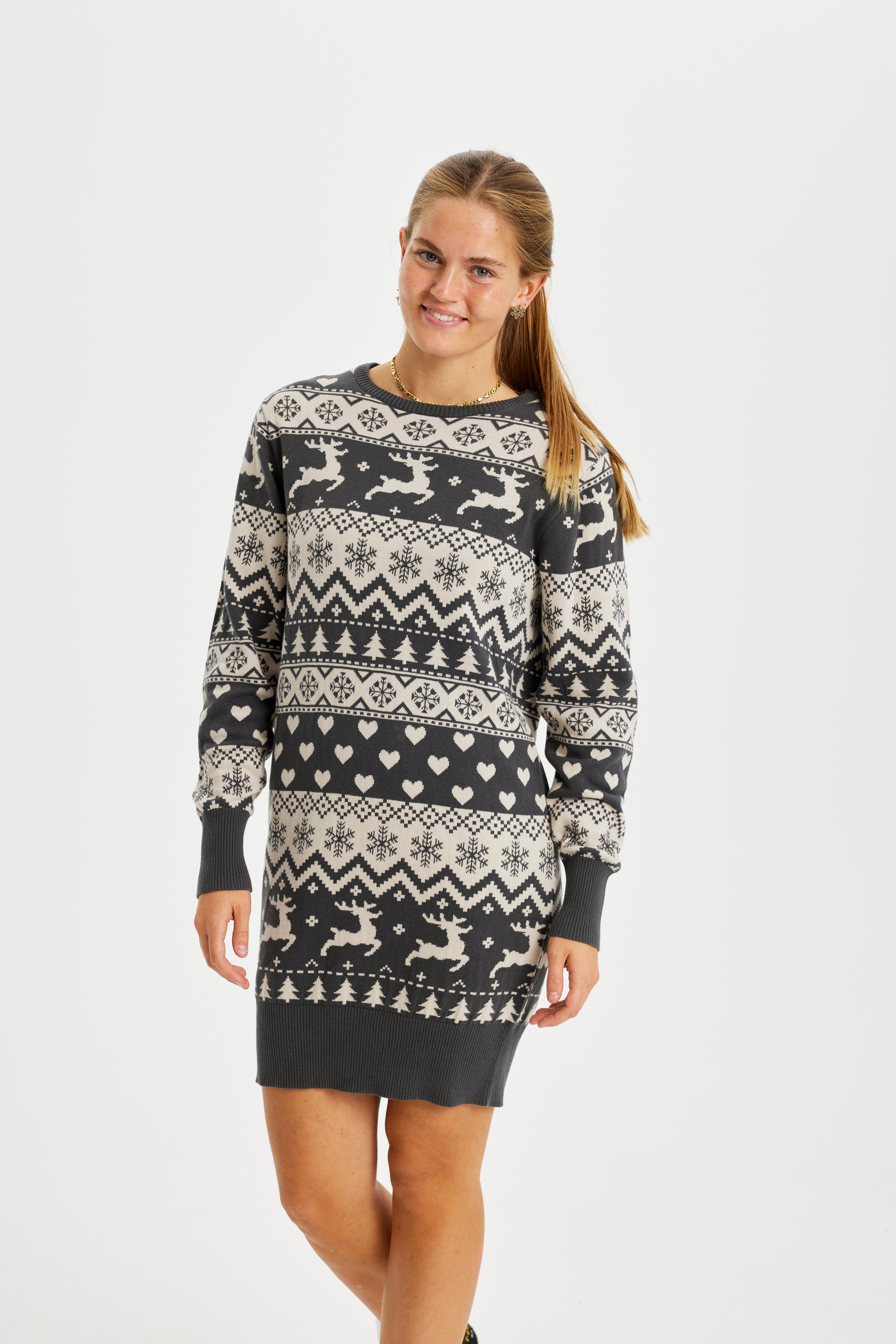 Una donna che indossa un abito natalizio in maglia grigia.